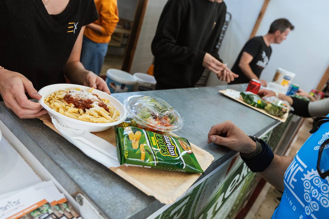 Plato de pasta, ensalada y snack en la barra de comidas del pabellón